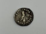 a silver coin with a bird on it sitting on top of a white surface