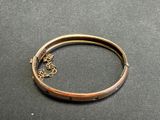 a close up of a gold bracelet with a chain on it