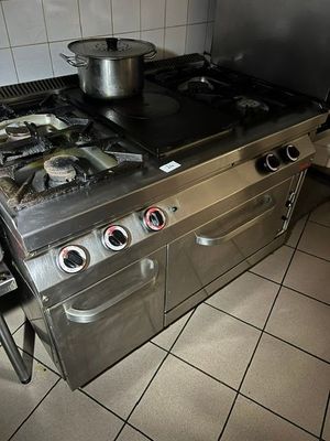 une cuisinière sur laquelle est posée une marmite dans une cuisine