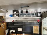 une cuisine équipée d'un réfrigérateur, d'une cuisinière, d'un micro-ondes et de placards