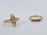 deux bagues en or et une bague en diamant sur une surface blanche