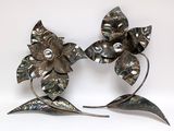 pair of silver flower brooches with pearls on a white background