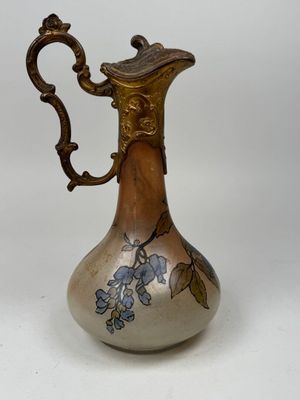 a silver and gold vase with blue flowers on it
