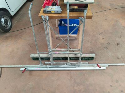 une petite table sur laquelle est posée un balai, dans un garage