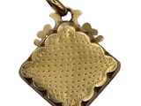 a close up of a gold plated pendant on a white background
