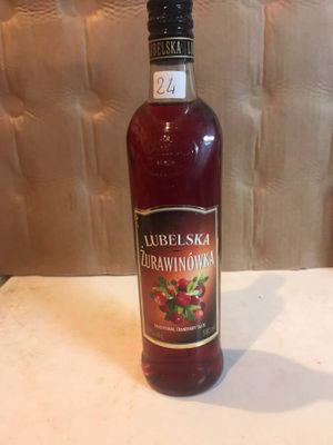 a bottle of liquor sitting on a table next to a wall