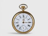 a gold pocket watch with roman numerals on it