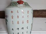 a vase with asian writing on it sitting on a shelf
