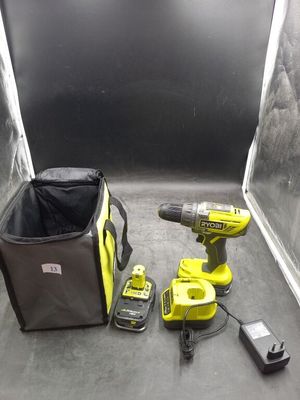a cordless drill and two batteries on the floor