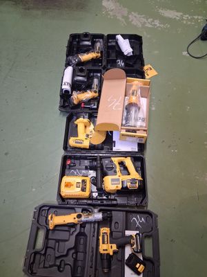 des outils de chantier jaunes et noirs posés sur un sol vert
