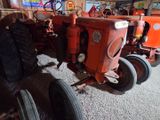 a red tractor that is parked in a garage