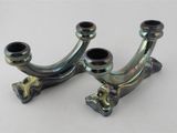 une paire de supports de tuyaux en métal chromé sur un fond blanc