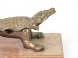 a bronze turtle on a wooden block on a white background