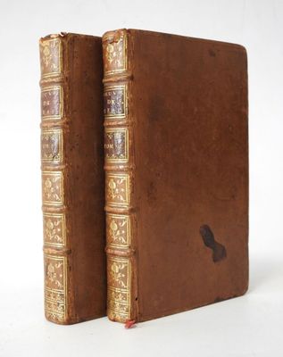un vieux livre à la couverture marron posé sur une table blanche