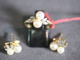 a ring, earrings, and ring with pearls on a table