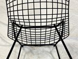 a black wire chair sitting on top of a white sheet