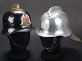 pair of silver and black helmets on display on a black surface