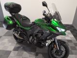 a picture of a green motorcycle parked on a checkered floor