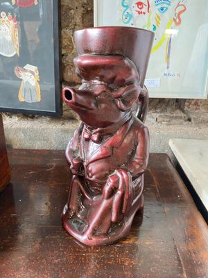 un vase rouge sur lequel est représenté un singe