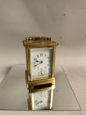 a gold clock sitting on top of a glass table
