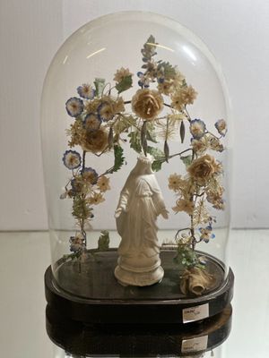 a glass dome with a statue inside of it on a table
