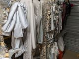 beaucoup de vêtements suspendus à une étagère dans une pièce