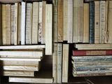 a lot of books that are stacked on a shelf