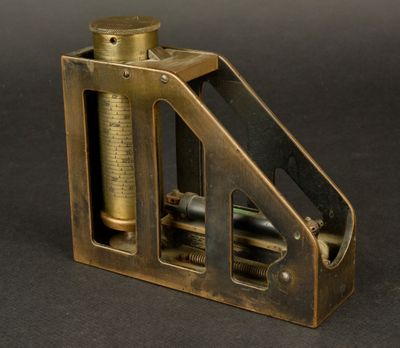 an antique brass plated machine with a cylinder on top of it