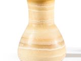 un petit vase posé sur une surface blanche