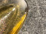 a bottle of olive oil sitting on the ground