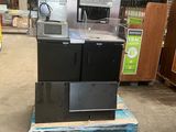 une pile d'appareils électroménagers posée sur une palette dans un entrepôt