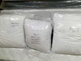 many bags of mattresses and pillows stacked on top of each other