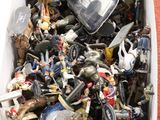 une boîte remplie de jouets de toutes sortes posée par terre