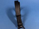 black leather belt on a blue surface with a metal buckle