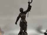 statue d'une femme tenant un drapeau posée sur une table