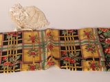 yellow and black plaid table runner with red and green flowers on it