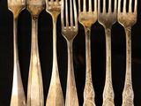 a lot of forks and spoons that are on a table
