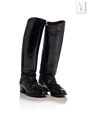 une paire de bottes noires posées sur une surface blanche
