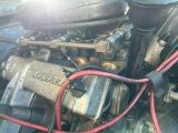 un gros plan d'un moteur de voiture auquel sont reliés des câbles