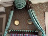 a bed with a canopy in a room with a chandelier