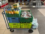 a cart full of drinks and sodas in a grocery store