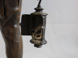 bronze statue of a boy holding a bell and a bell hanging from a chain