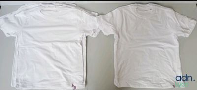 two white t - shirts sitting next to each other on a table