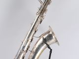 an old silver saxophone sitting on top of a black stand
