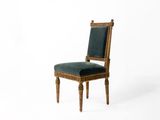 une image représentant une chaise en bois dont l'assise est recouverte d'un tissu vert