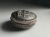 a silver box sitting on a white surface with a black background