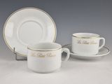 une tasse et une soucoupe blanches ornées d'une bordure dorée