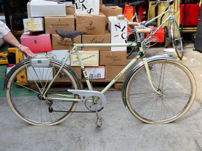un homme debout à côté d'un vélo garé devant des cartons