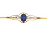 a close up of a gold and blue stone pin