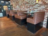 une rangée de banquettes dans un restaurant avec un mur en briques
